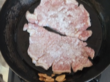 フライパンで豚を焼く